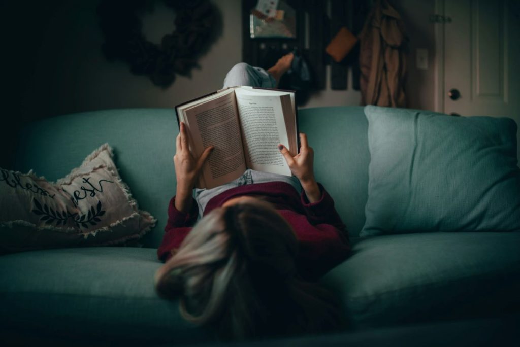 woman reading book while lying down the beauty of literature