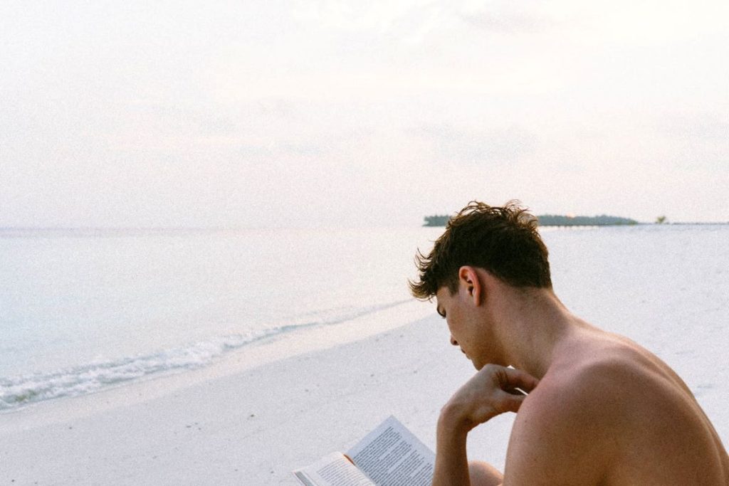 man reading book on the beach why we should learn philosophy