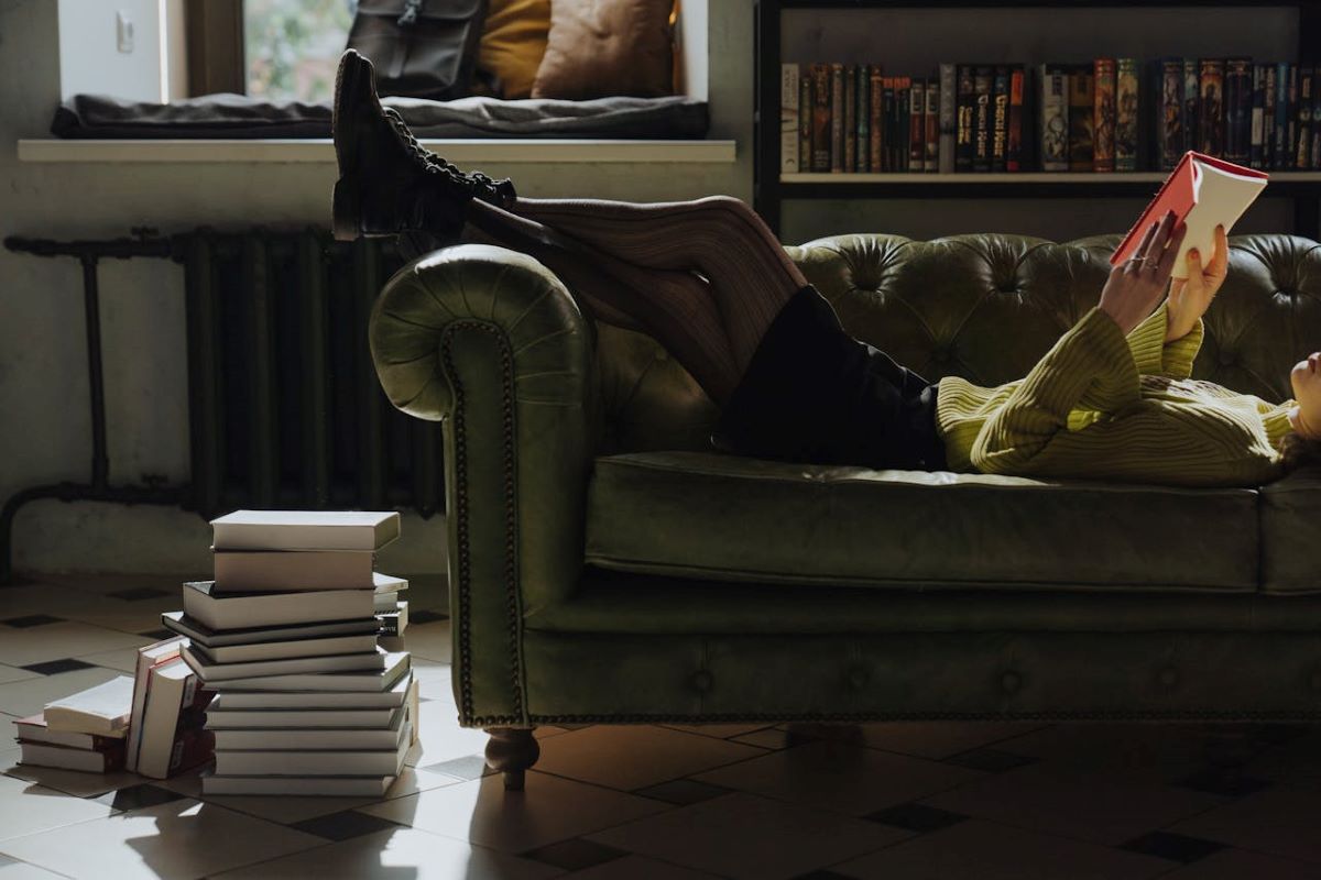 woman reading book on couch why we should learn philosophy