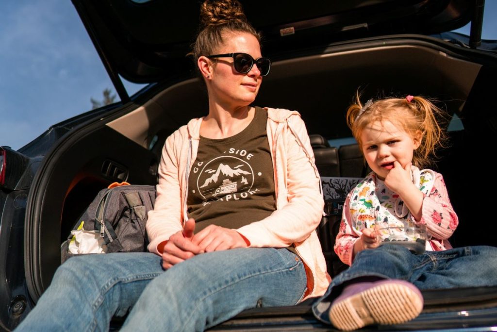 mother with child sitting on car trunk thinking about helping parents cope with a child's diagnosis