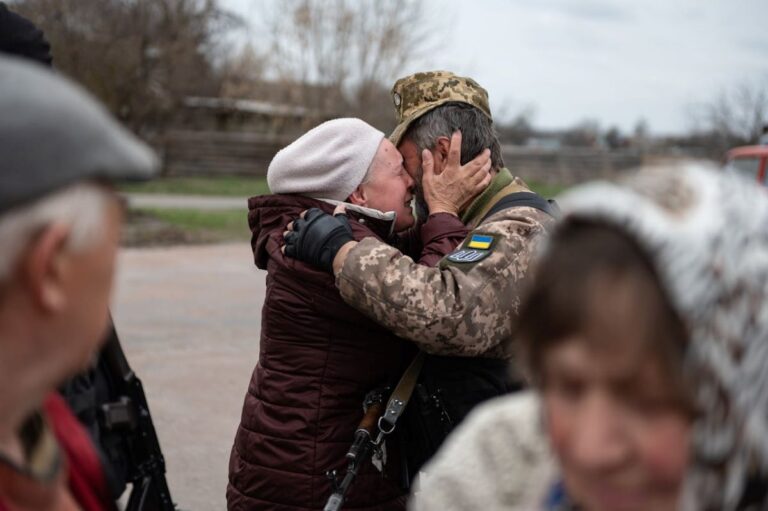 family kissing soldier displaying the effects of war on people's lives