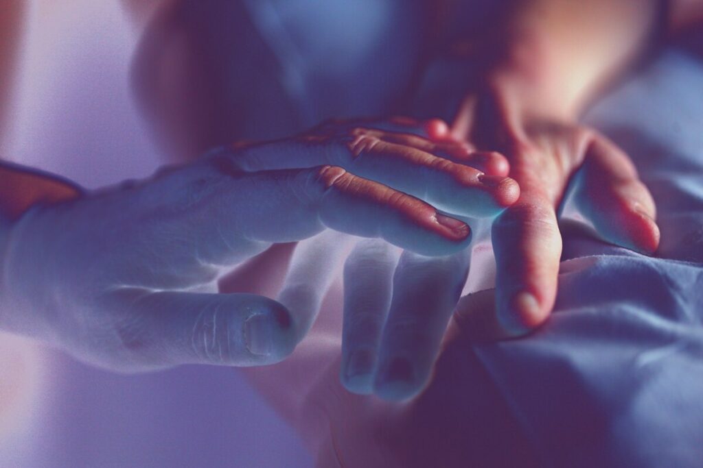 a photo of a hand on top of another person's hand