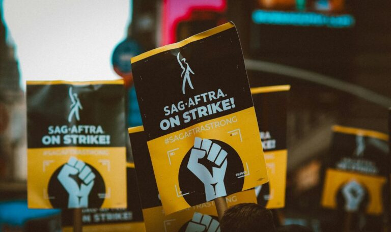 image of people carrying banners and placards saying “Sag•Aftra On Strike!” showing examples of novels about labor unions