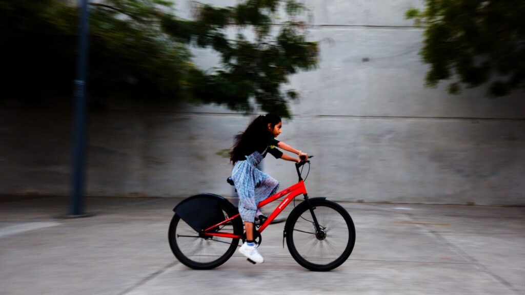 image of girl riding a bicycle showing everyone the reason why kids need exercise