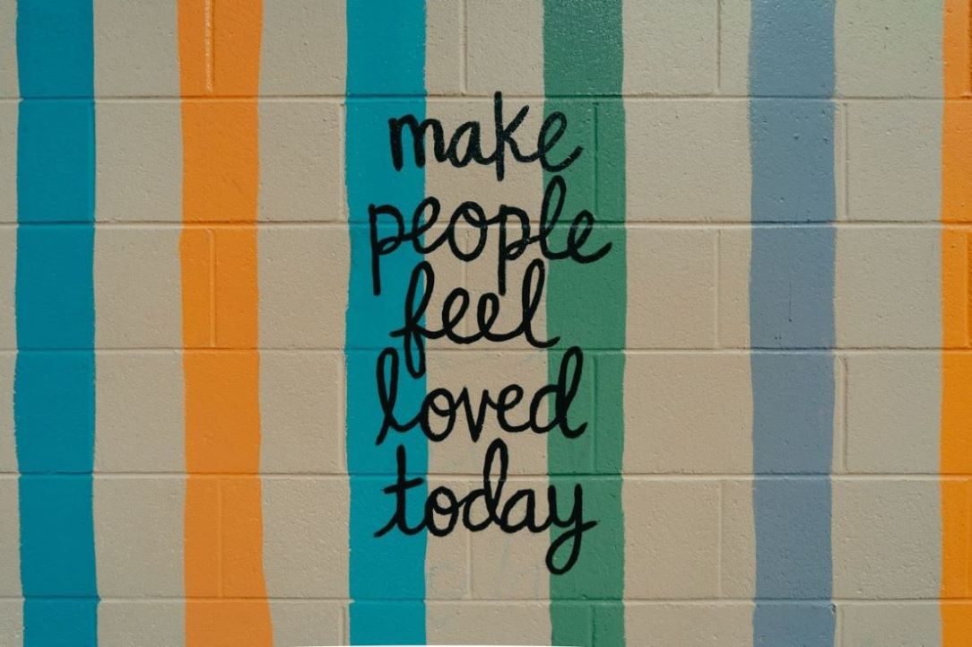 Wall art that says, "Make people feel loved today."