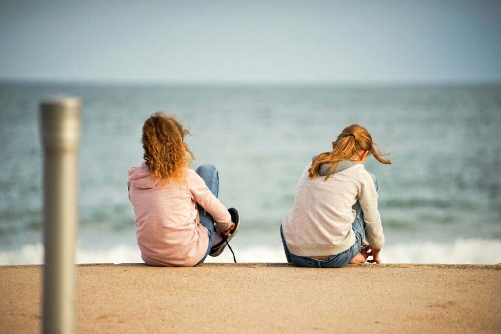 Two girls looking at the sea