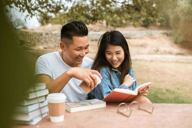 Two people reading a book, laughing