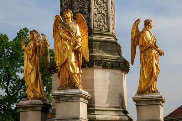 A trio of golden statues of angels.