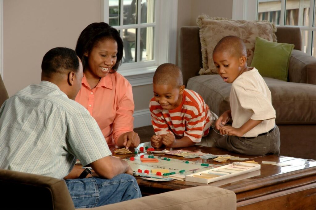 image of a family playing monopoly and what it means to take care of children