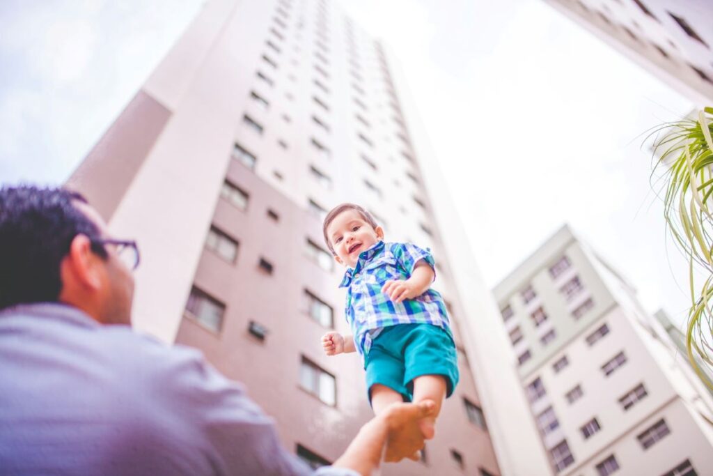 image of father holding up child in his hand showing the essence of what it means to take care of children