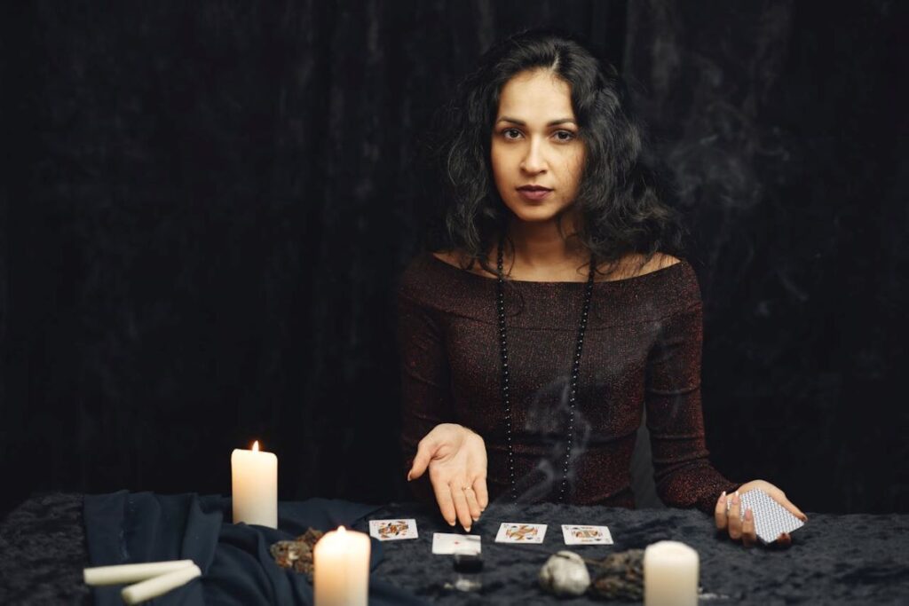 image of a woman presenting cards with lighted candles to show the process of psychic reading