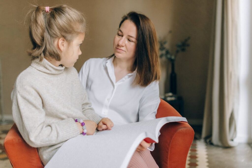 image of a mother teaching her kid to read braille to support them growing up as a blind child