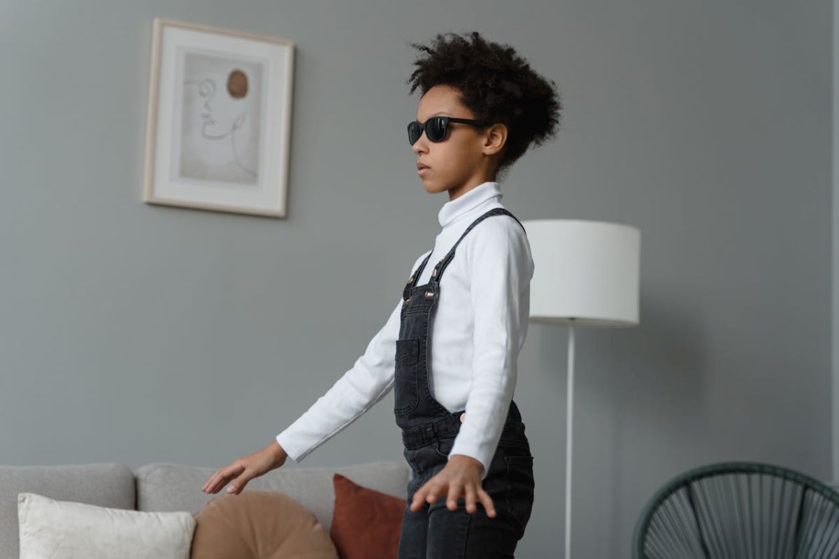 image of blind child with glasses walking around showing what growing up as a blind child is about