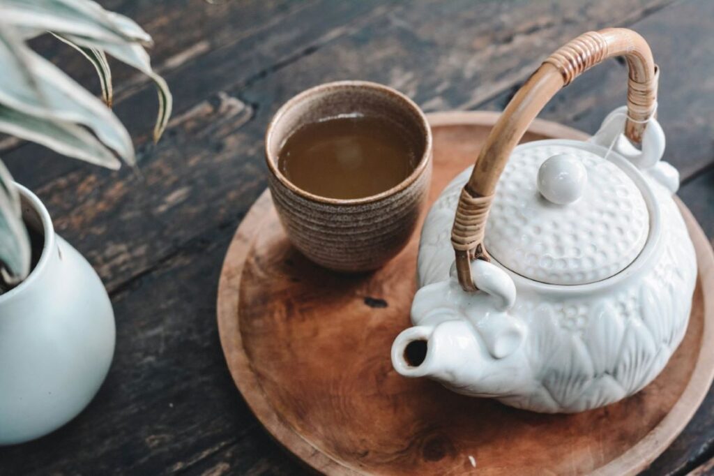 A kettle beside a cup of tea