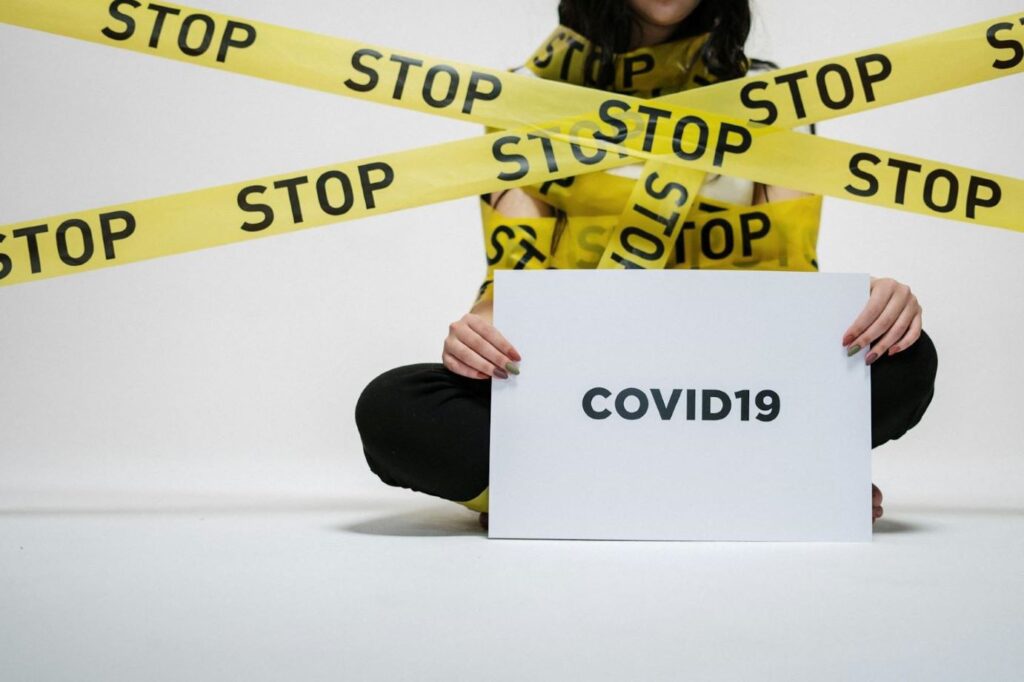 A girl holding a placard saying COVID-19.