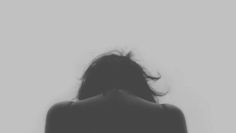 a woman with her head down, depicting a deep dive into the rare mental disorders