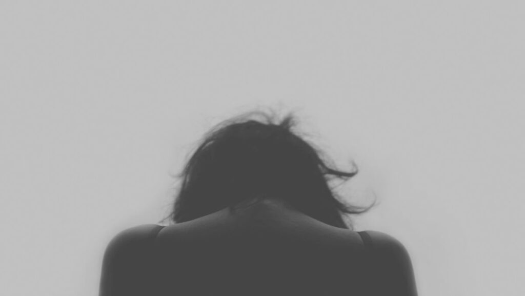 a woman with her head down, depicting a deep dive into the rare mental disorders