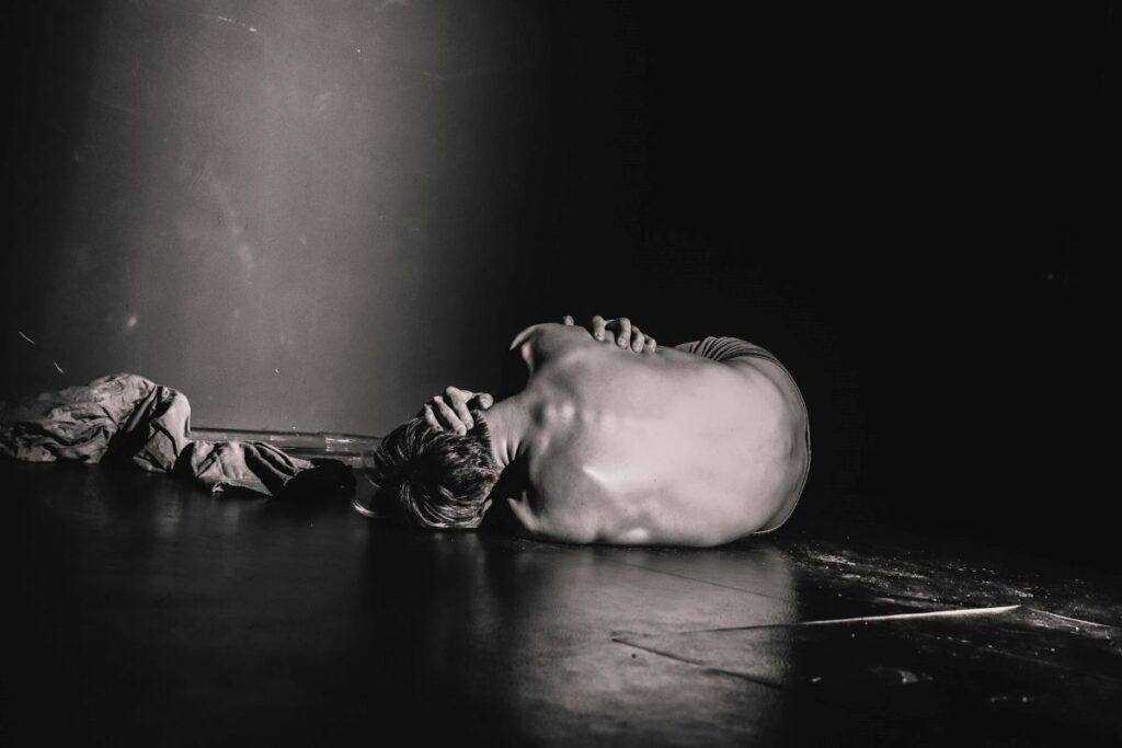 a man lying on the floor with his back facing