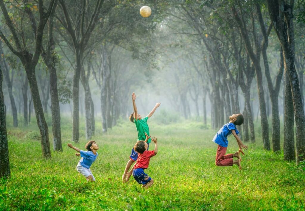 image of children reaching for a ball high up in the air representing the beauty of why a child needs to dream big