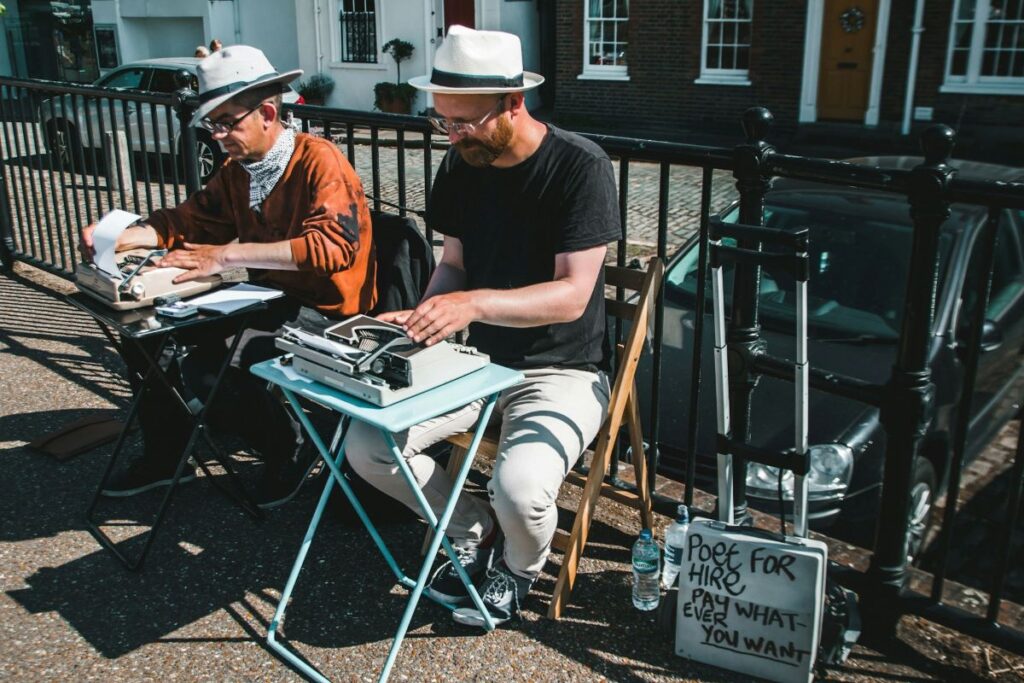 image of poets typing on typewriters and making poems for anyone who pays displaying the role of poets in society