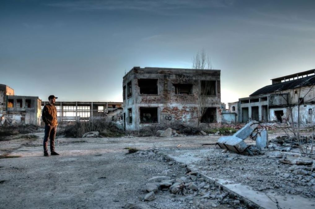 A ruined landscape with a man surveying the scene.