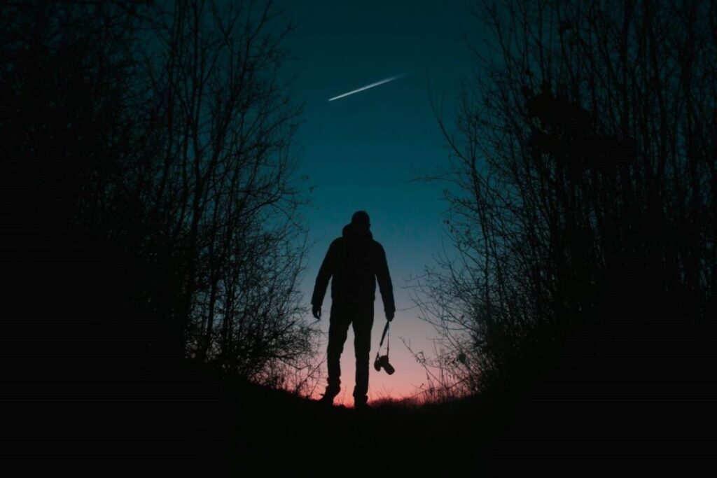 A man looking at a shooting star.