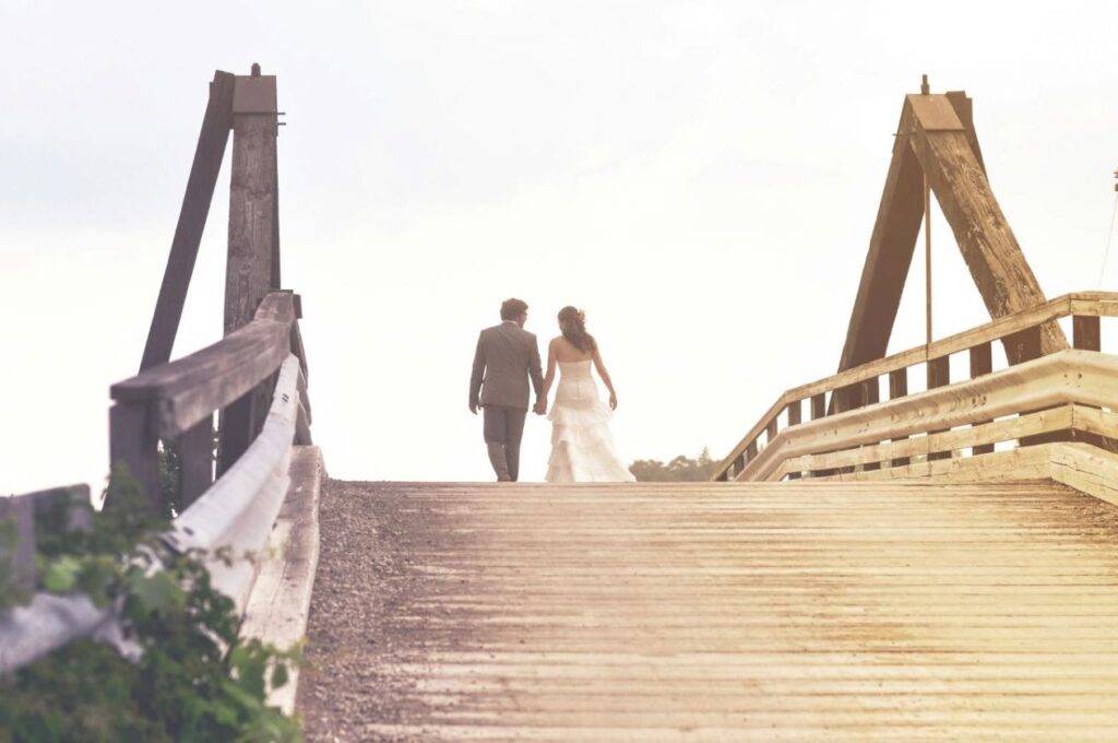 A married couple walking over a bridge.