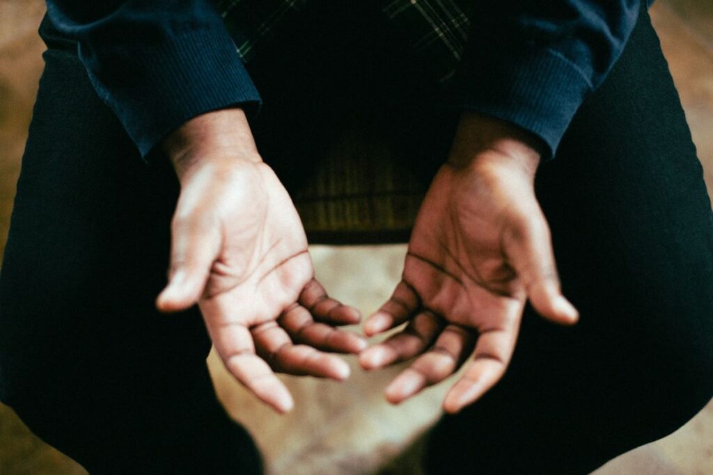 a person’s hands sprawled out while praying to God