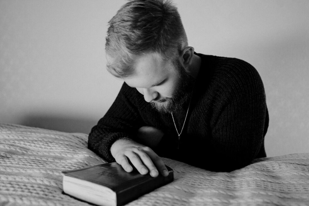 a photo of a man praying alone in his room