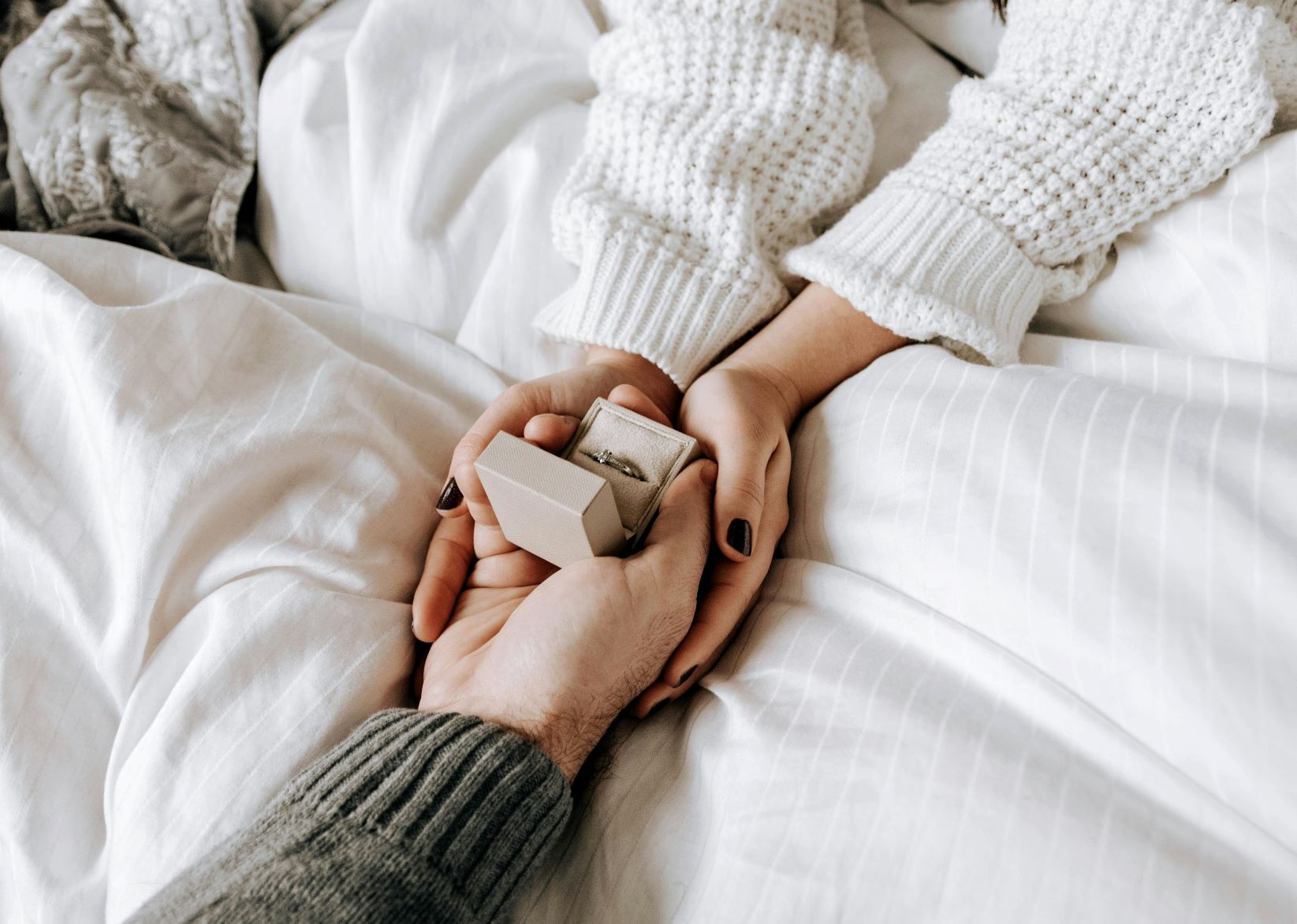 hands from a couple who are holding their wedding rings as they successfully overcome boredom in marriages